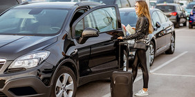 Günstig und sicher am Flughafen BER parken - McParking Berlin Frau steigt in Auto