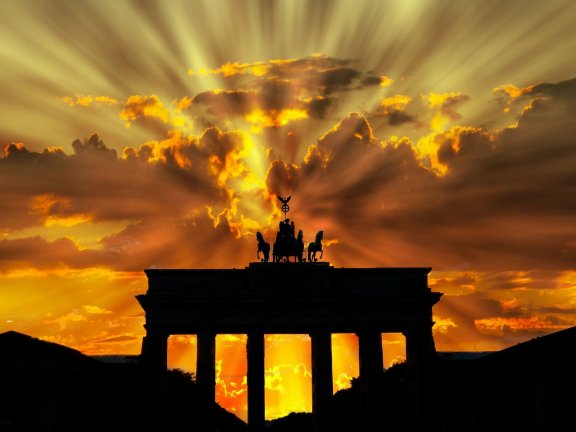 The Brandenburg Gate set against a cloudy evening sky and lights