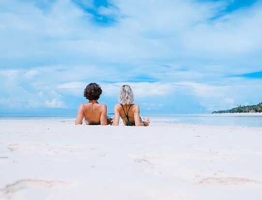 Paar am sonnigen Strand liegend