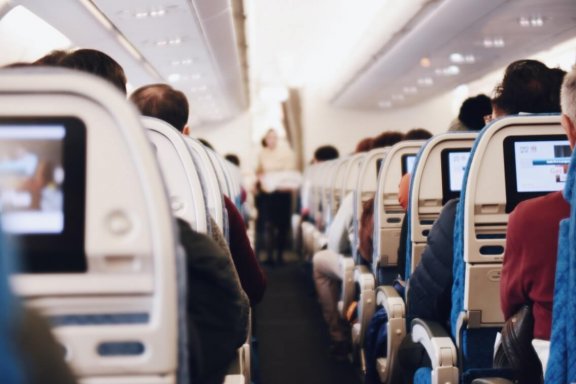 Passagiere im Flugzeug – Was ist bei Reisen während Corona zu beachten