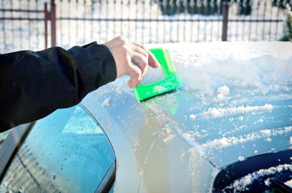 Auto wird vom Schnee befreit