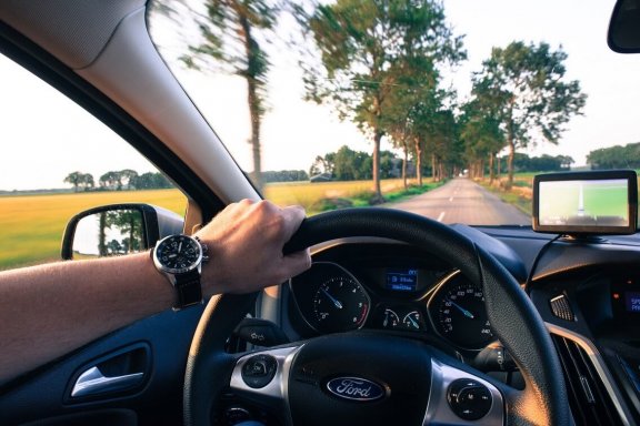 Motorists drive on the country road - driving fun in summer