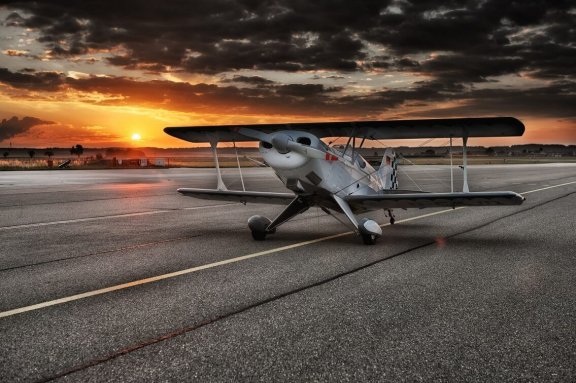 Doppeldecker startet bei Sonnenuntergang vom Flughafen Bremen