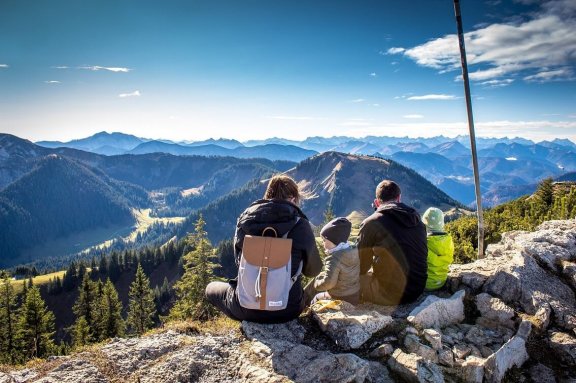 Familie sitzt auf Bergspitze