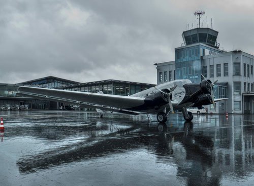 Paderborn Lippstadt Airport with tower in front of a Ju52 aircraft.