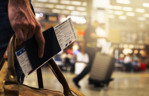 Ręka z paszportem i biletem lotniczym
