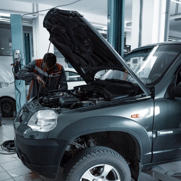 Car mechanic checks the engine compartment