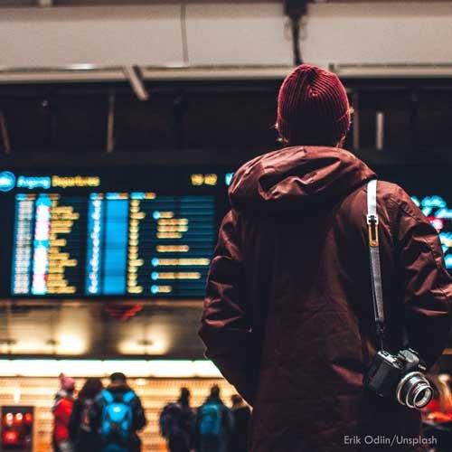 Reisender vor einer Anzeigetafel mit Abflügen im Terminal