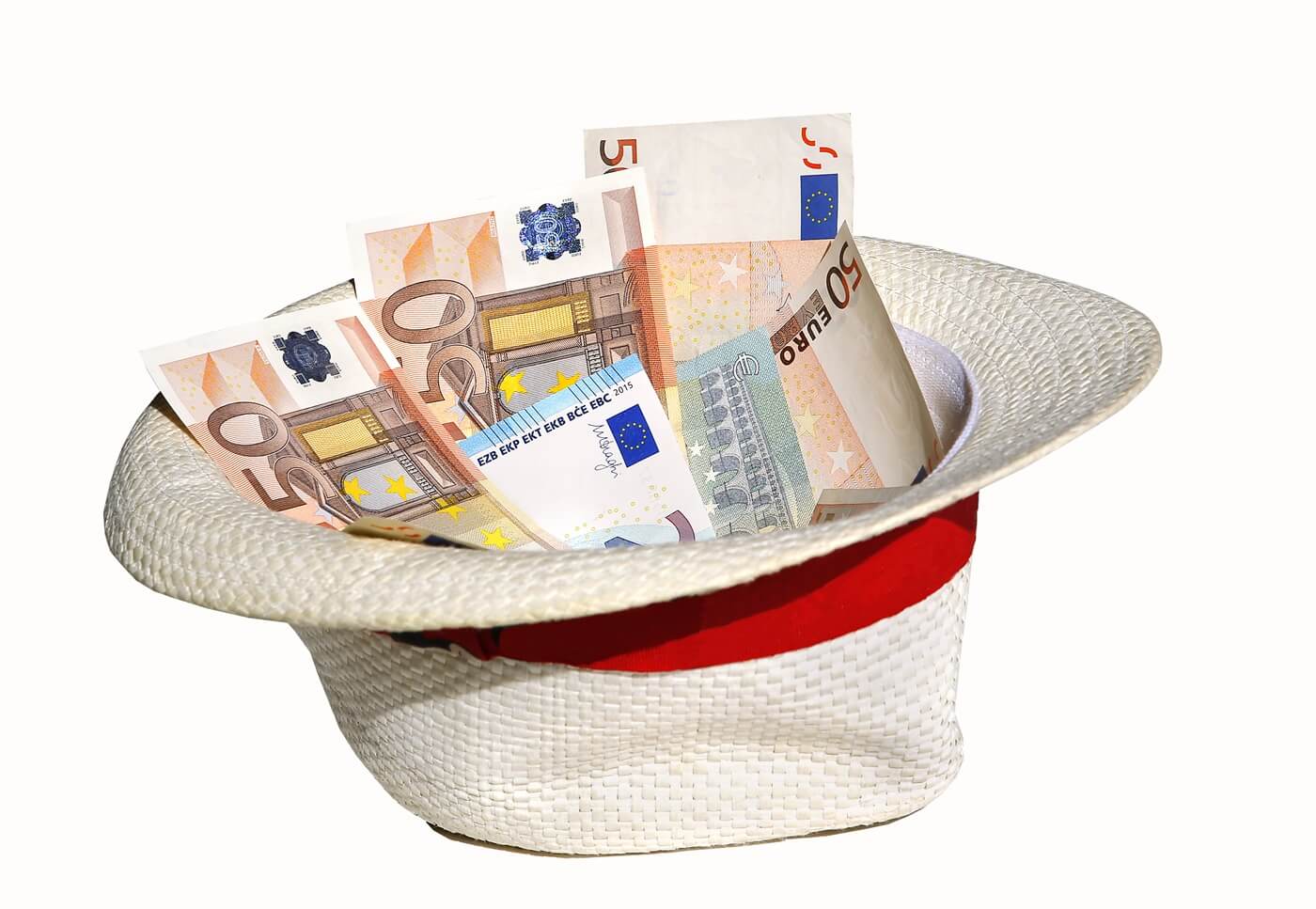 A white hat with a red ribbon is filled with banknotes.