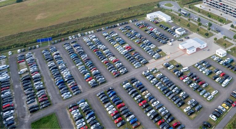 Parkování u BER na otevřeném prostranství McParking - Různá vozidla zaparkovaná u BER, pohled na otevřené prostranství ze vzduchu
