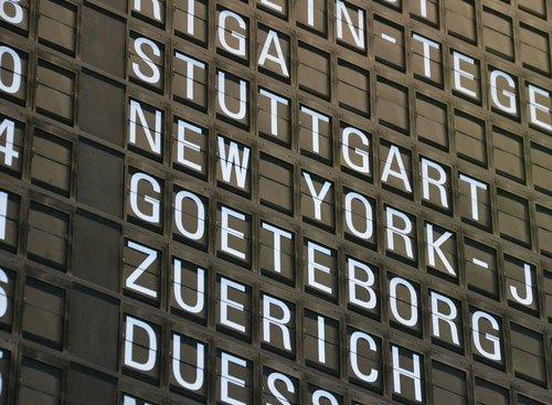 Vývěsní tabule na letišti ukazuje různé lety