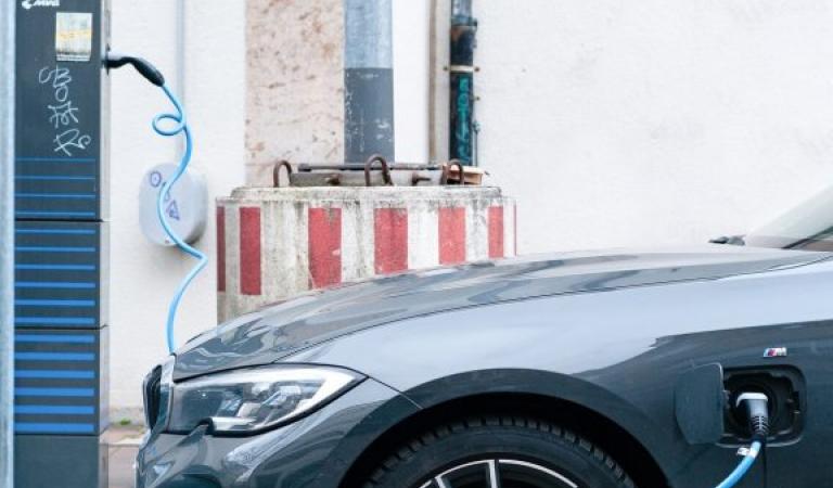 Electric car connected to charging station by cable