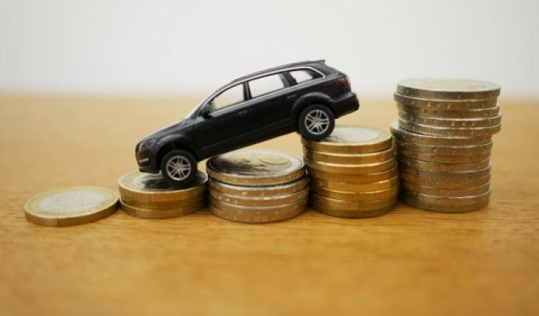 Toy car on euro coins - buying a car thanks to low VAT?