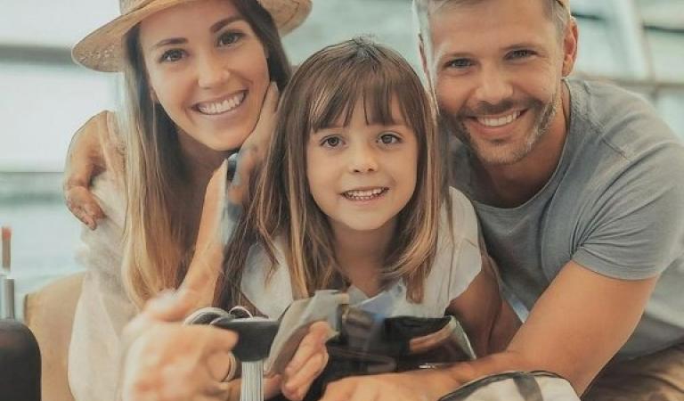 šťastná rodina se zavazadly před odletem