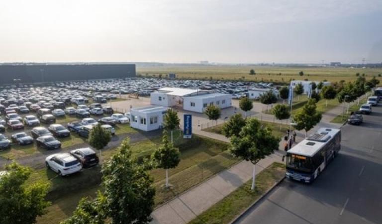 Záběr z dronu na parkoviště s kyvadlovým autobusem před ním