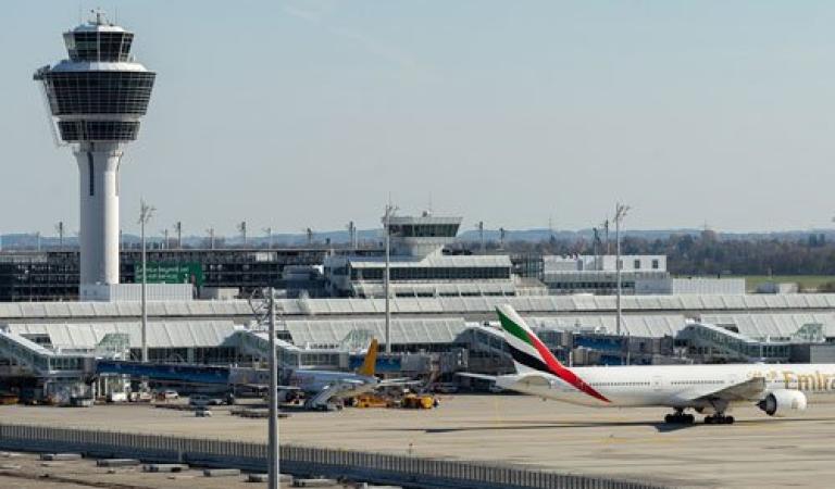 Mnichovské letiště s věží, odbavovací plochou, letadly a terminálem