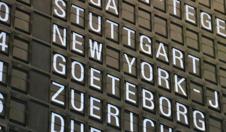 Vývěsní tabule na letišti ukazuje různé lety